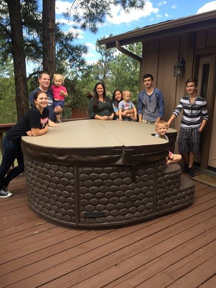 Family on a wood deck with their new hot tub