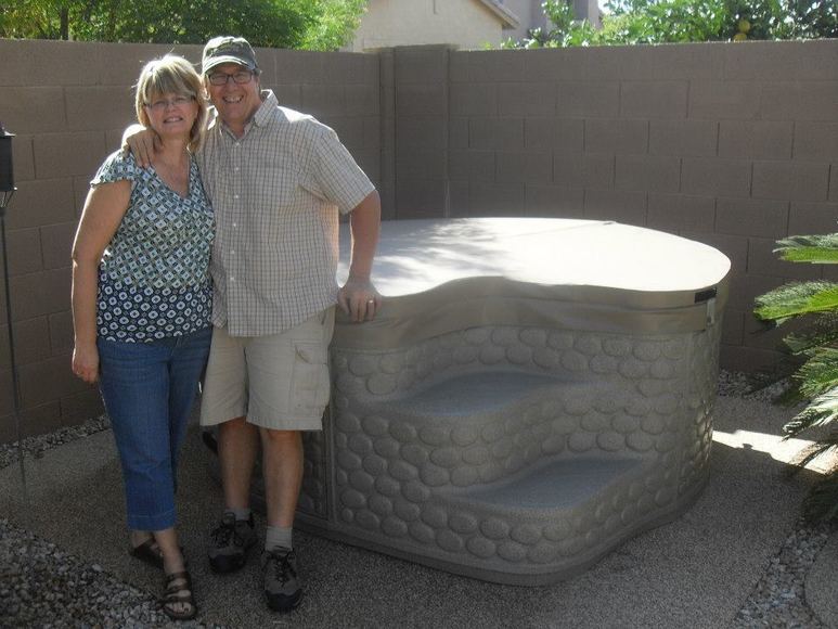Couple standing with their new backyard spa